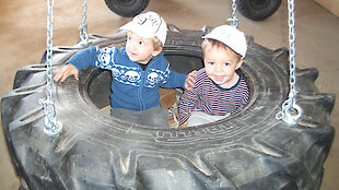 Kinder in der Reifenschaukel - Spielerlebnisse auf dem Ederhof